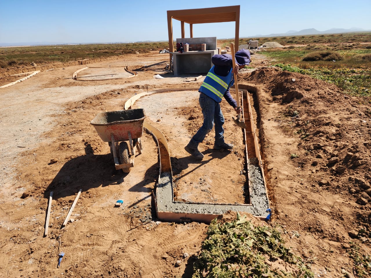 Colado de guarniciones en el área verde; pérgola terminada al fondo
